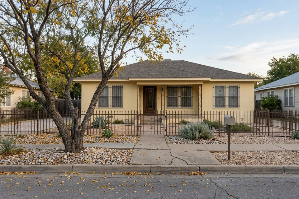Illustration of a yellow stucco house with an iron fence