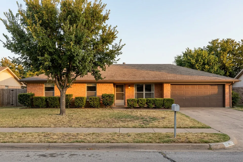 Illustration of a 1970s brick ranch house with a two-car garage