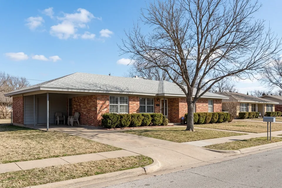 Illustration of a 1960s red brick ranch house with a carport