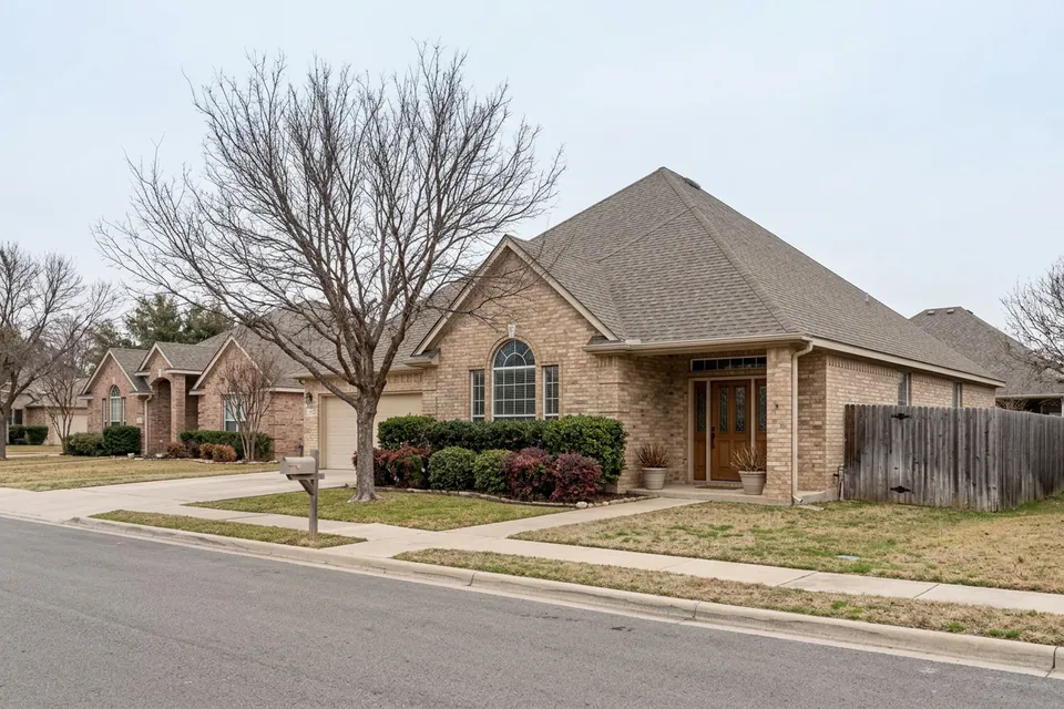 Illustration of a 1990s tan brick house with a tall roof
