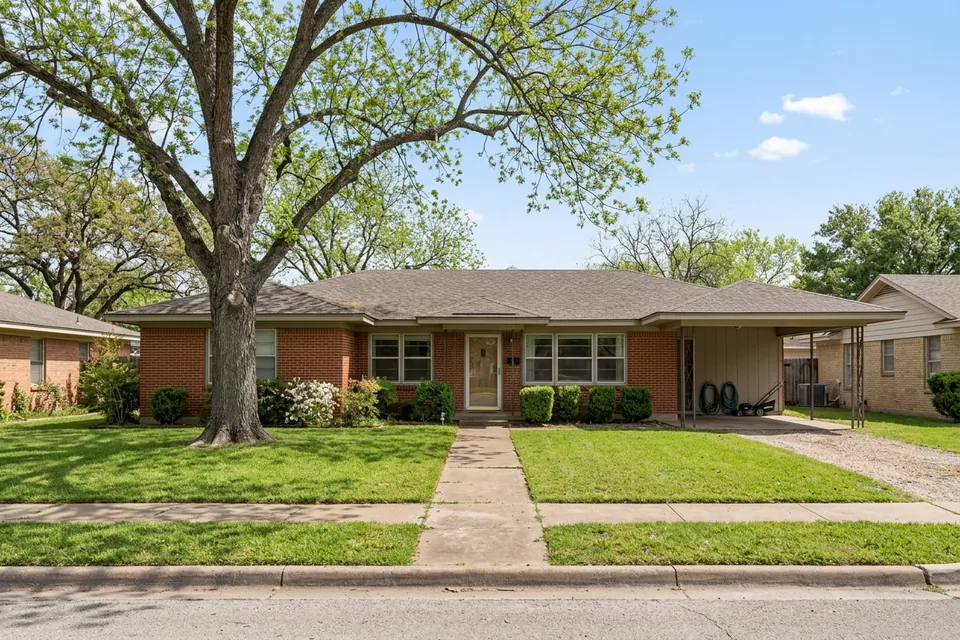 Illustration of a 1960s red brick ranch house with a carport