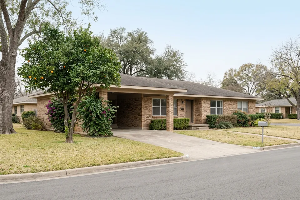 Illustration of a 1970s brick ranch house with a carport