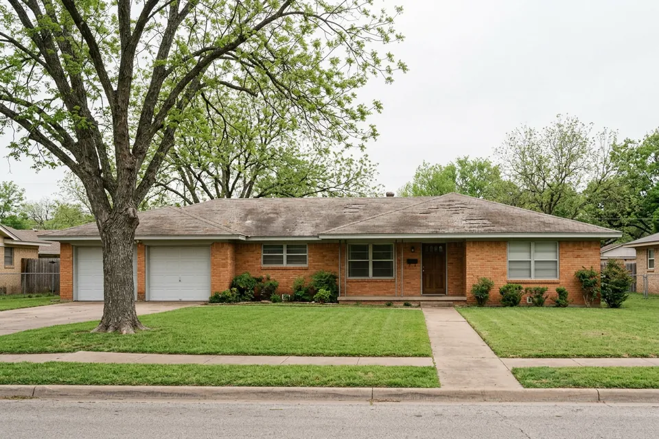 Illustration of a 1970s brick ranch house with a two-car garage
