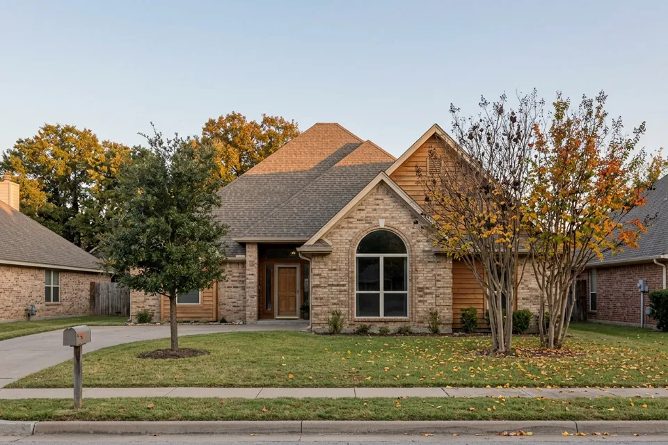 Illustration of a 1990s tan brick house with a tall roof