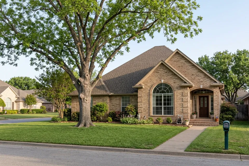 Illustration of a 1990s tan brick house with a tall roof